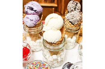 No Churn Vanilla Ice Cream shown in cones with sprinkles and cherries on the side.