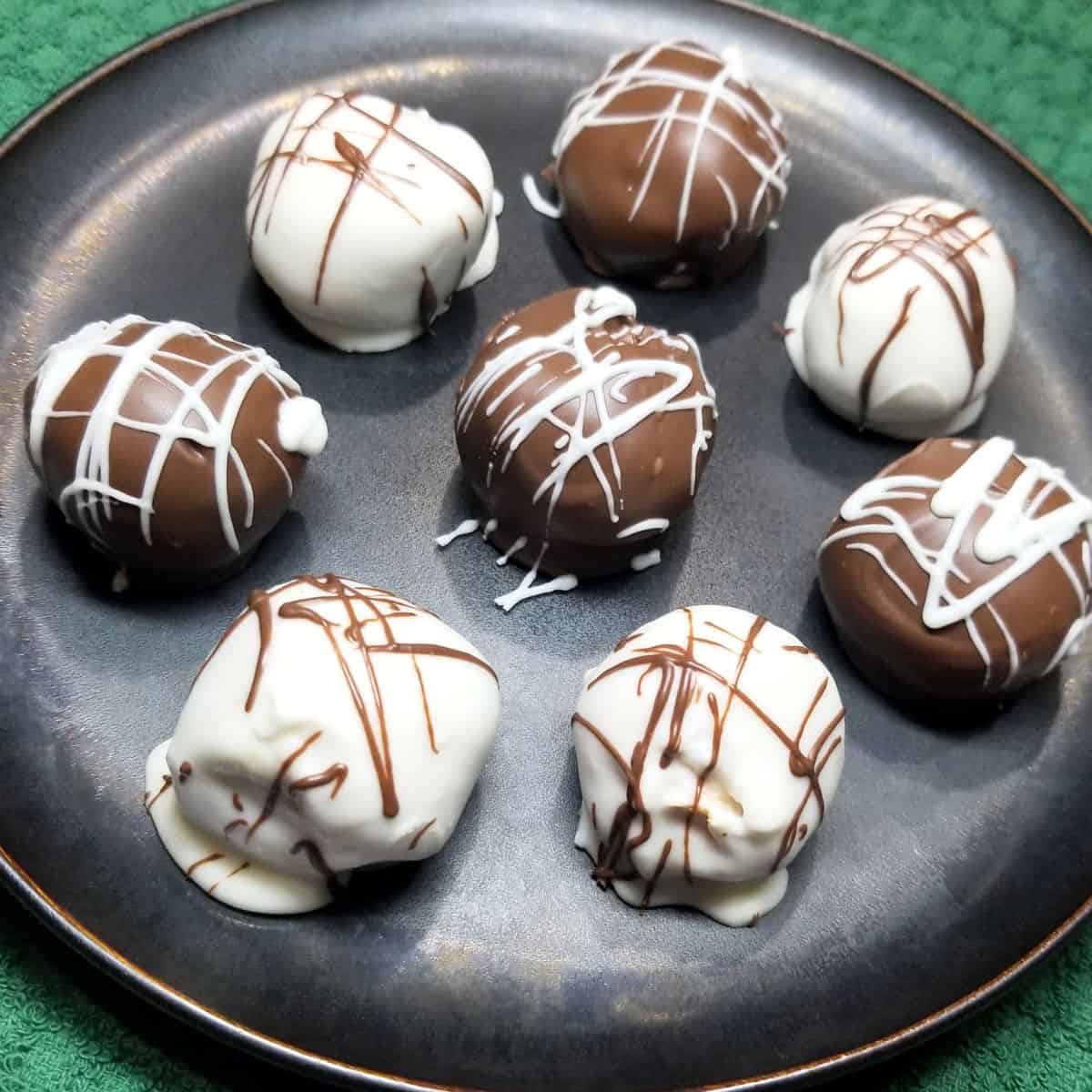 Peanut butter balls on a black plate.
