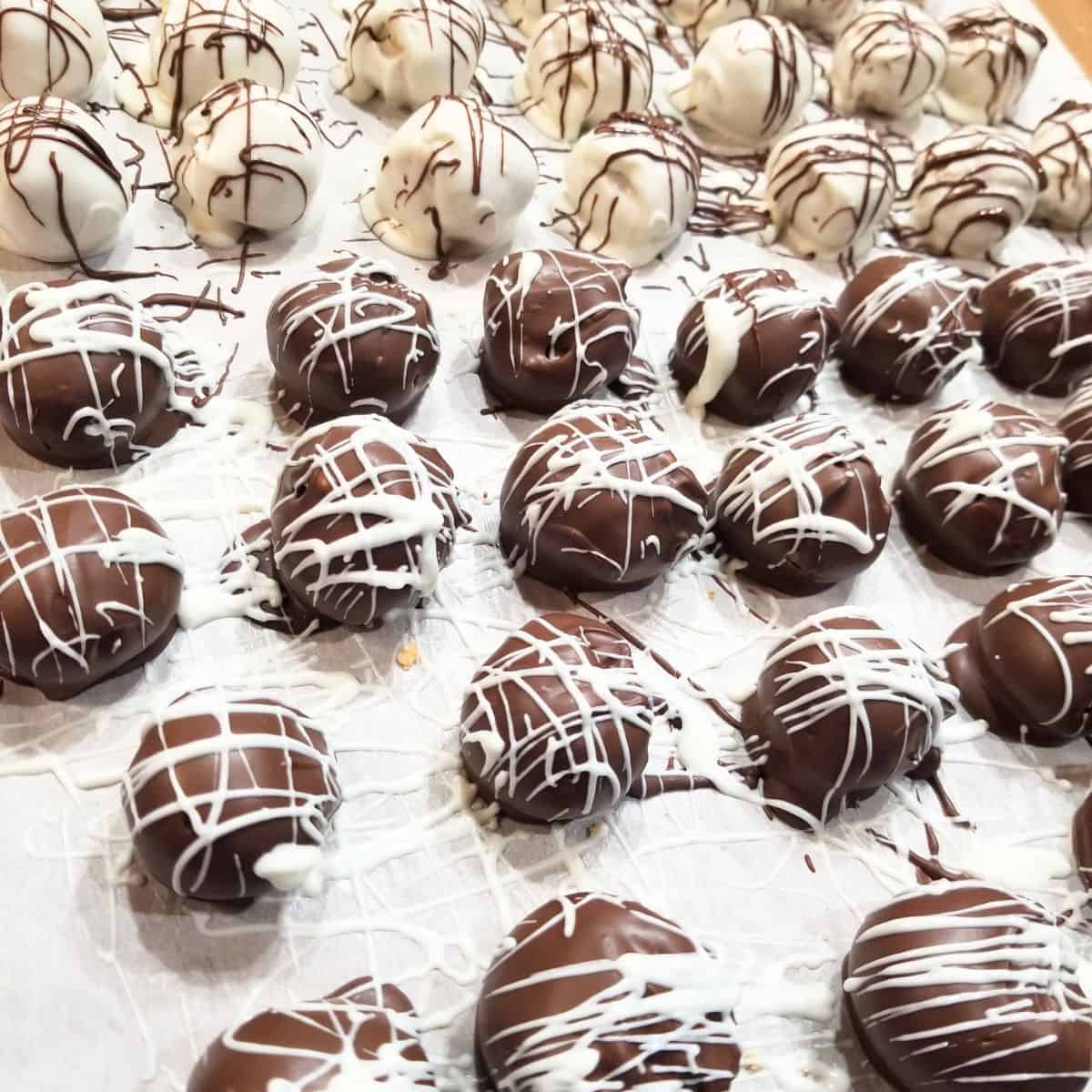 White and chocolate dipped balls on parchment paper.