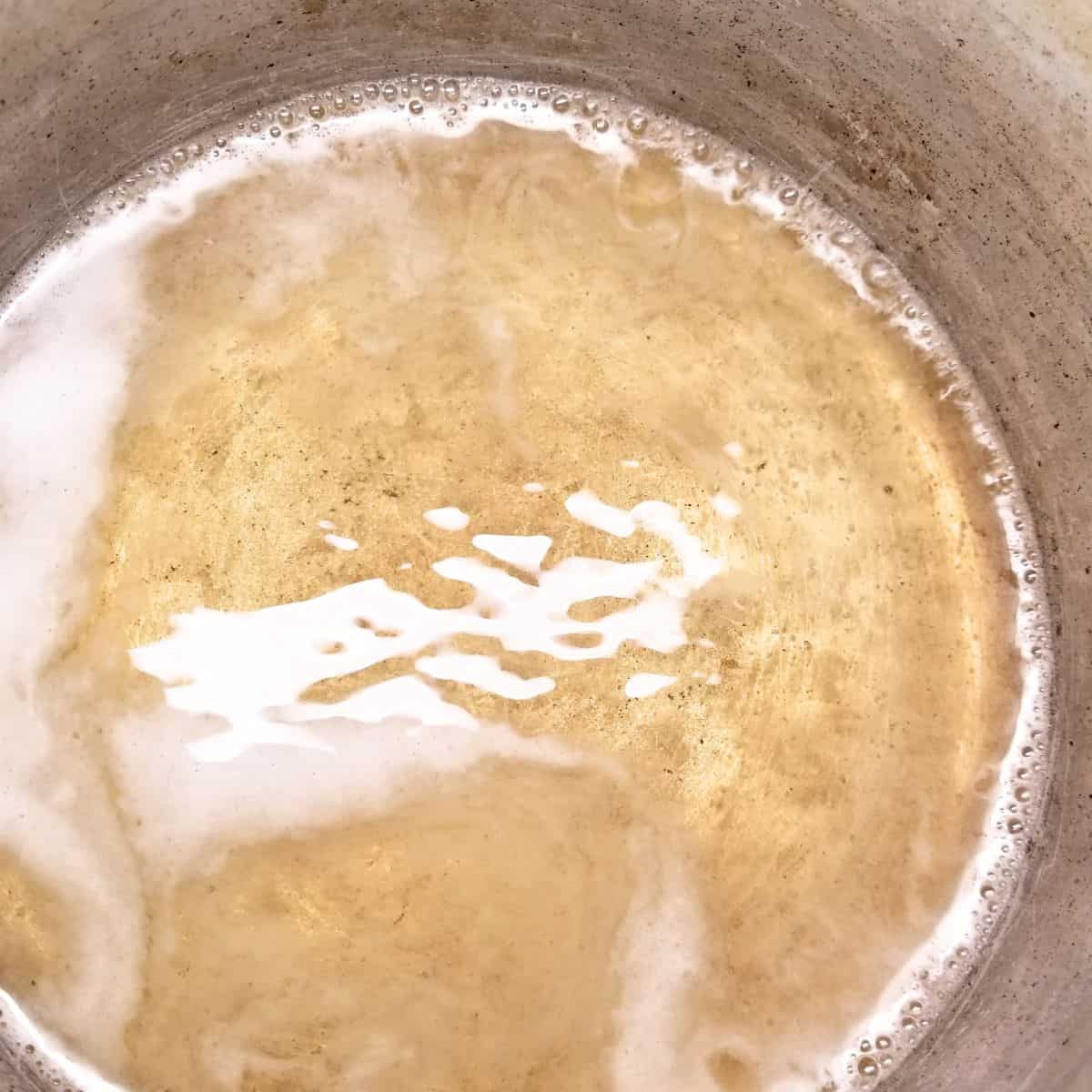 Pickling liquid for pickled onions in a pot on the stove.