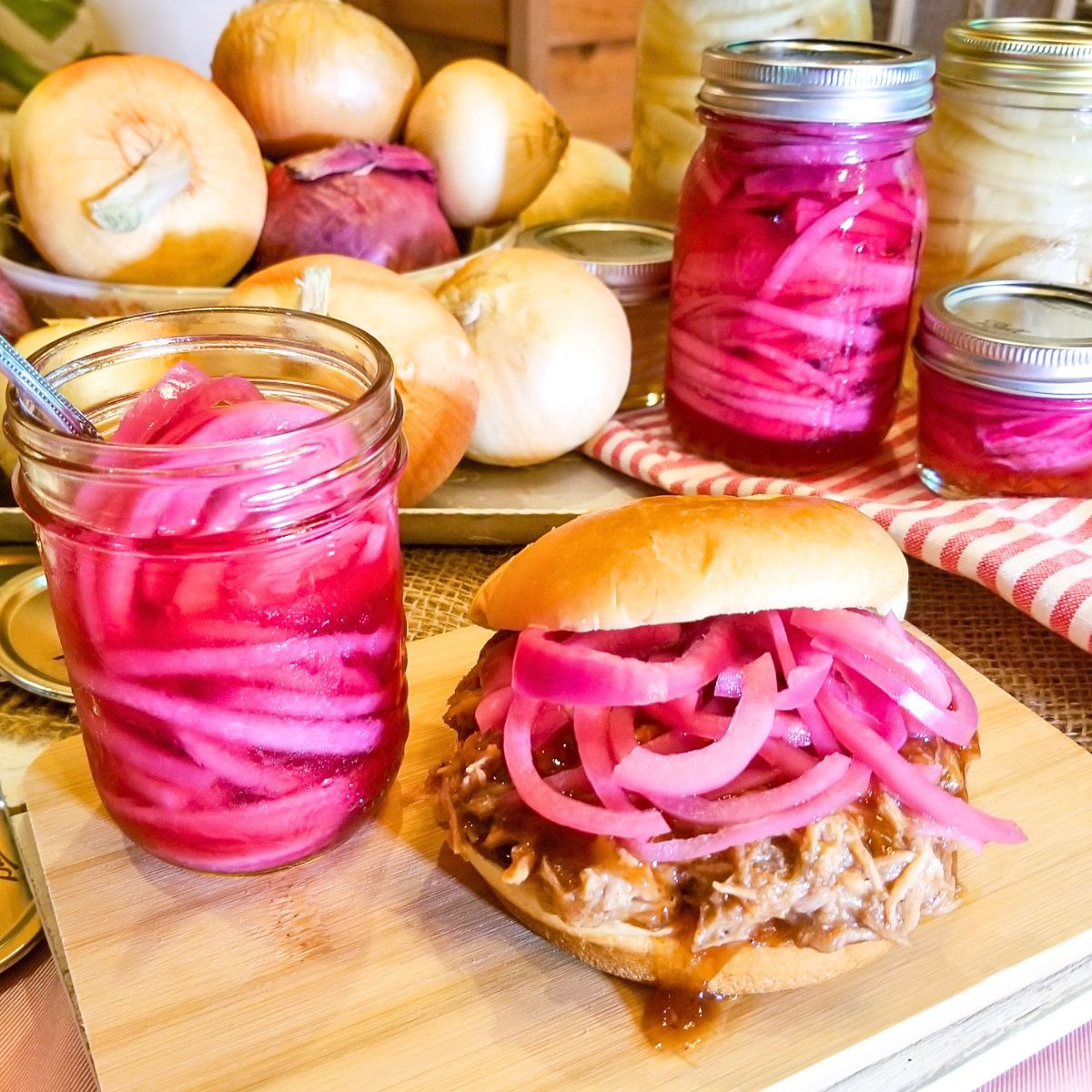 Pickled red onions in a mason jar and on top of a bbq sandwich. Onions in the background.