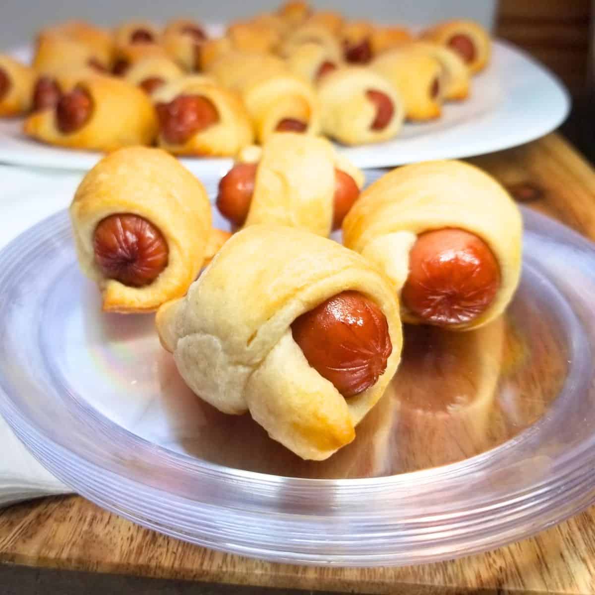 Pigs in a blanket on a serving platter and plate.