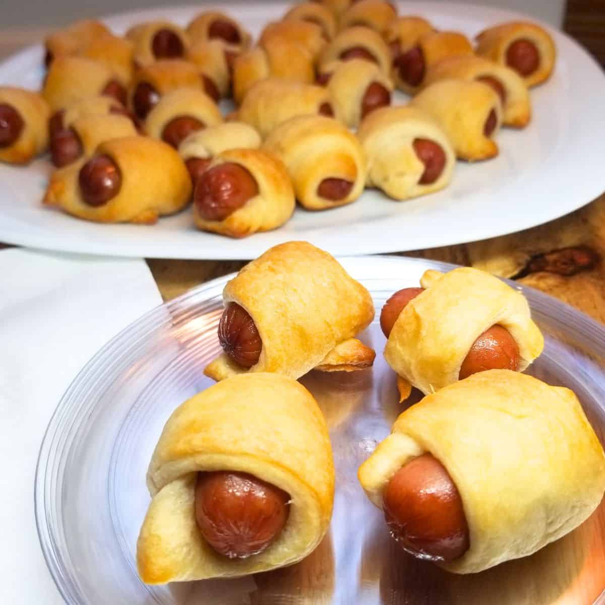 Pigs in a blanket on a serving platter and plate.