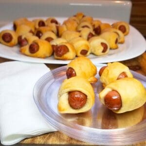 Pigs in a blanket on a serving plate.