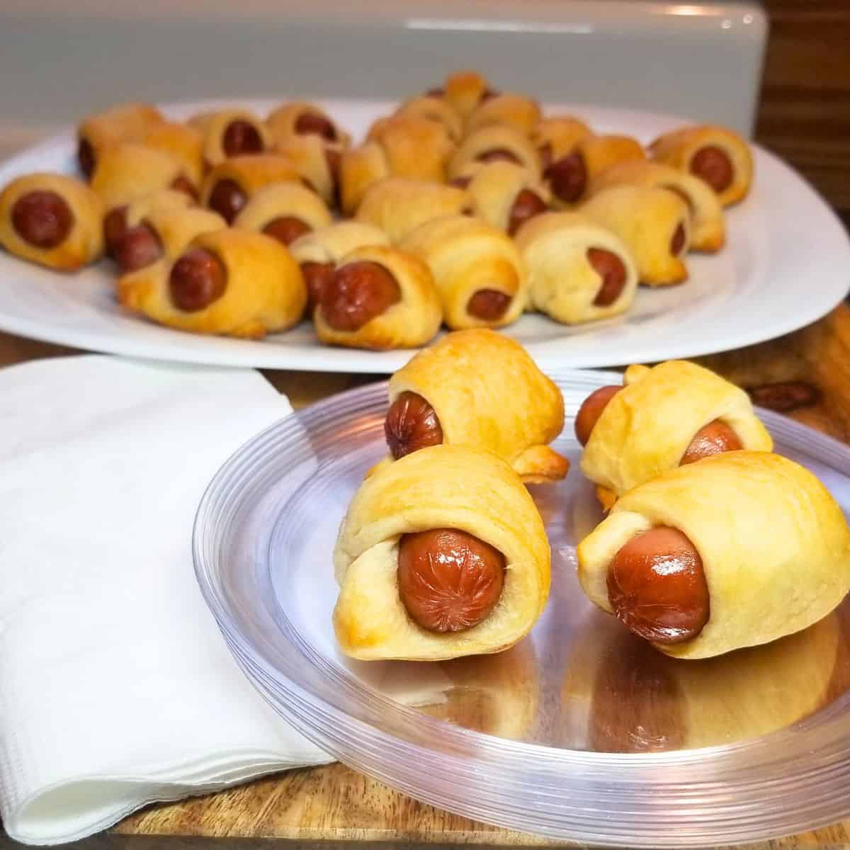 Pigs in a blanket on a serving plate.