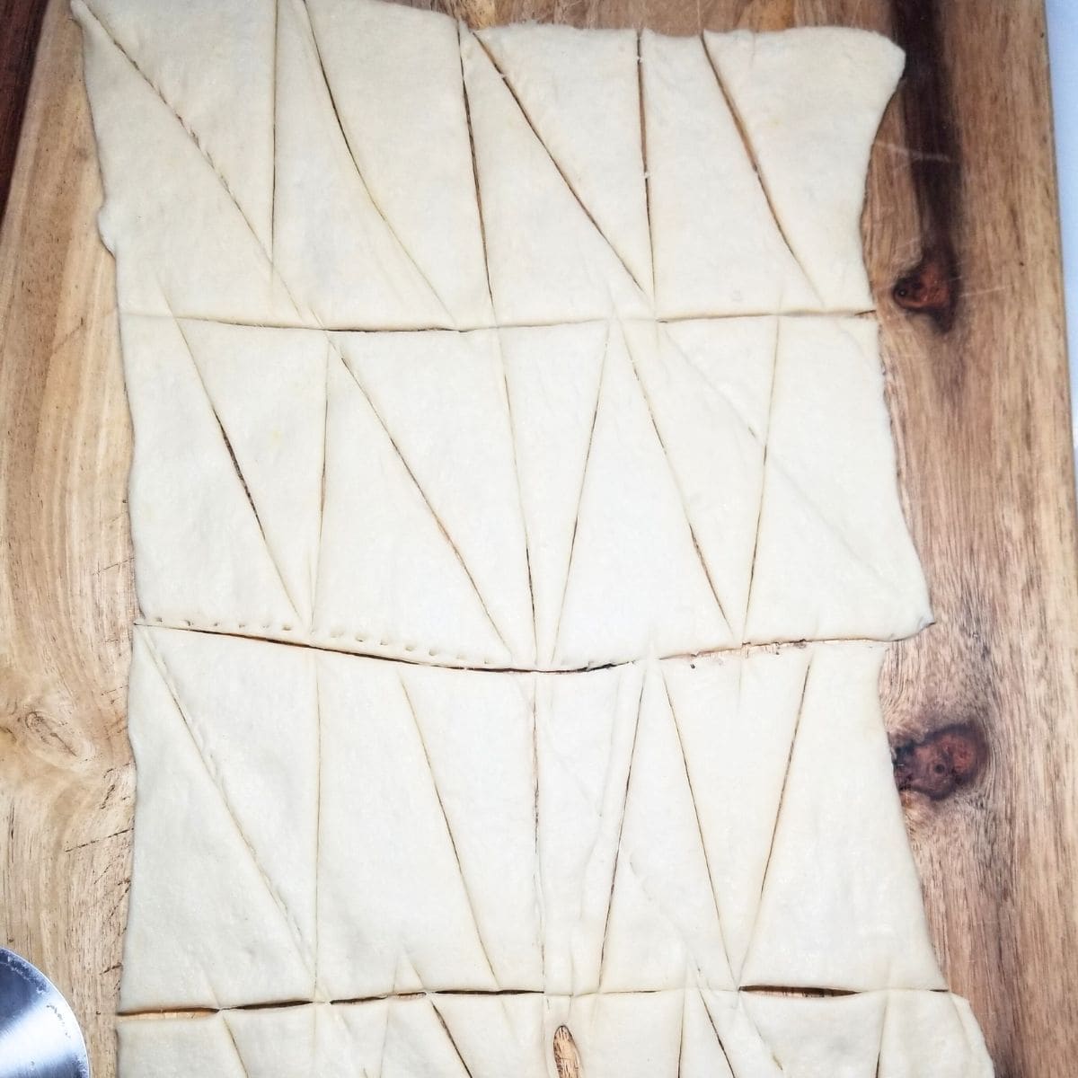 Crescent dough cut into small triangles on a cutting board.