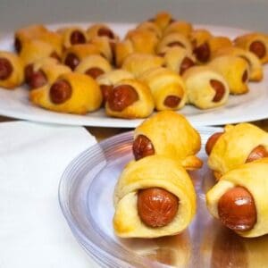 Pigs in a blanket on a serving plate.