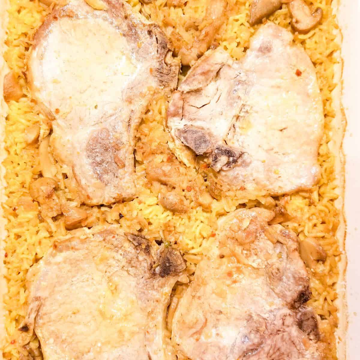 Baked pork chops and rice in a baking dish ready to eat.