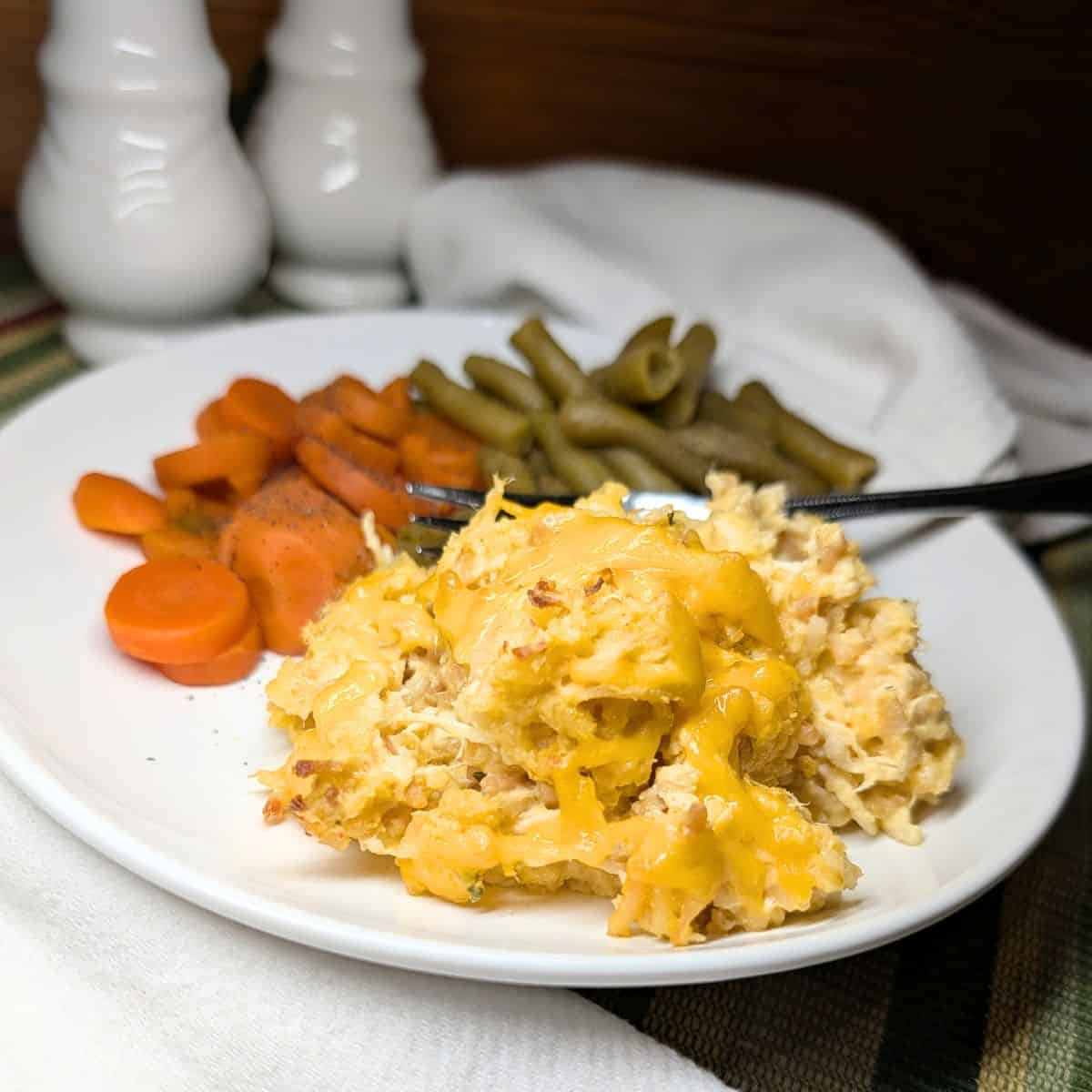 Chicken and rice casserole on a serving plate with vegetables.
