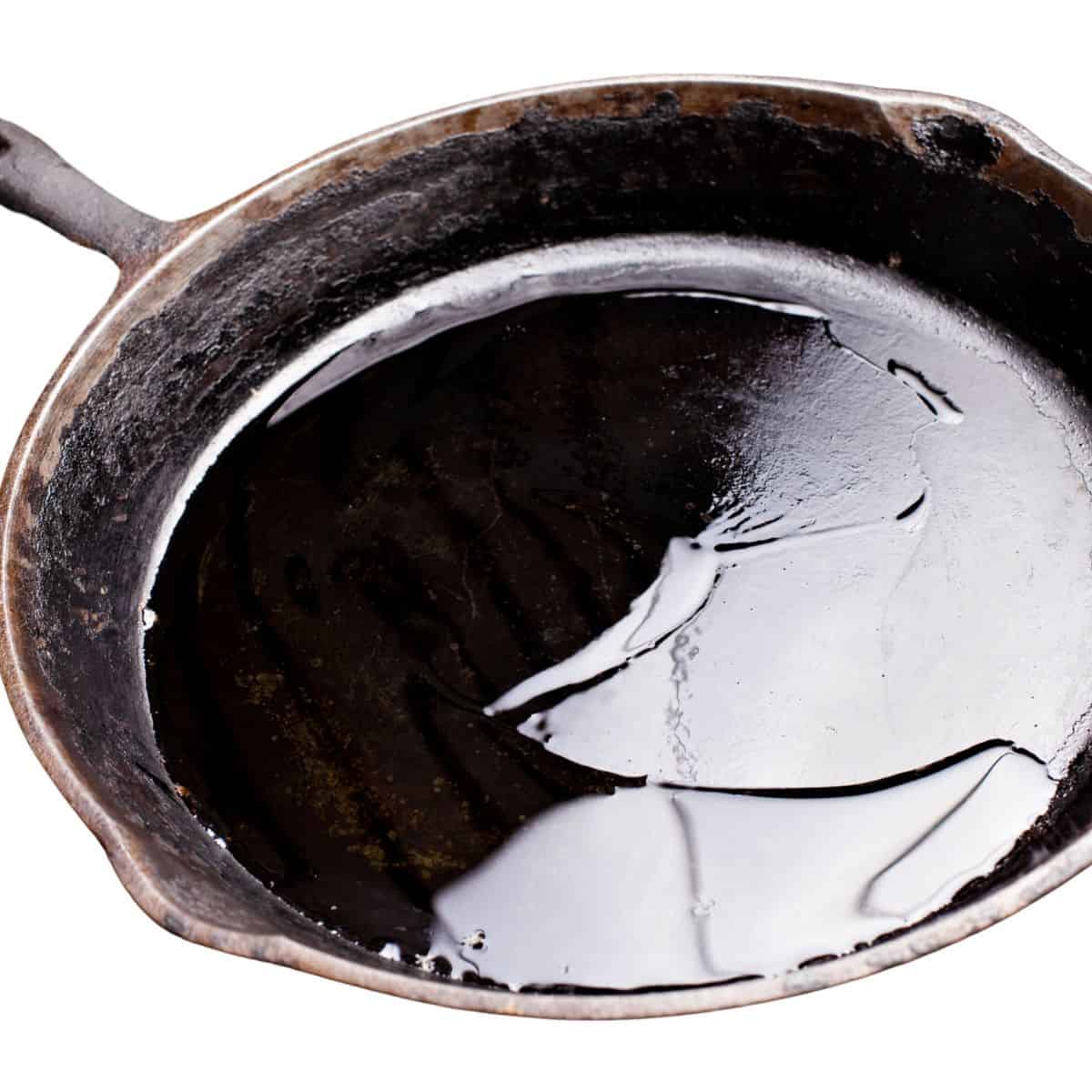 Cast iron skillet with cooking oil in the bottom.