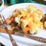 Shepherd's Pie on a white plate with a fork and knife.
