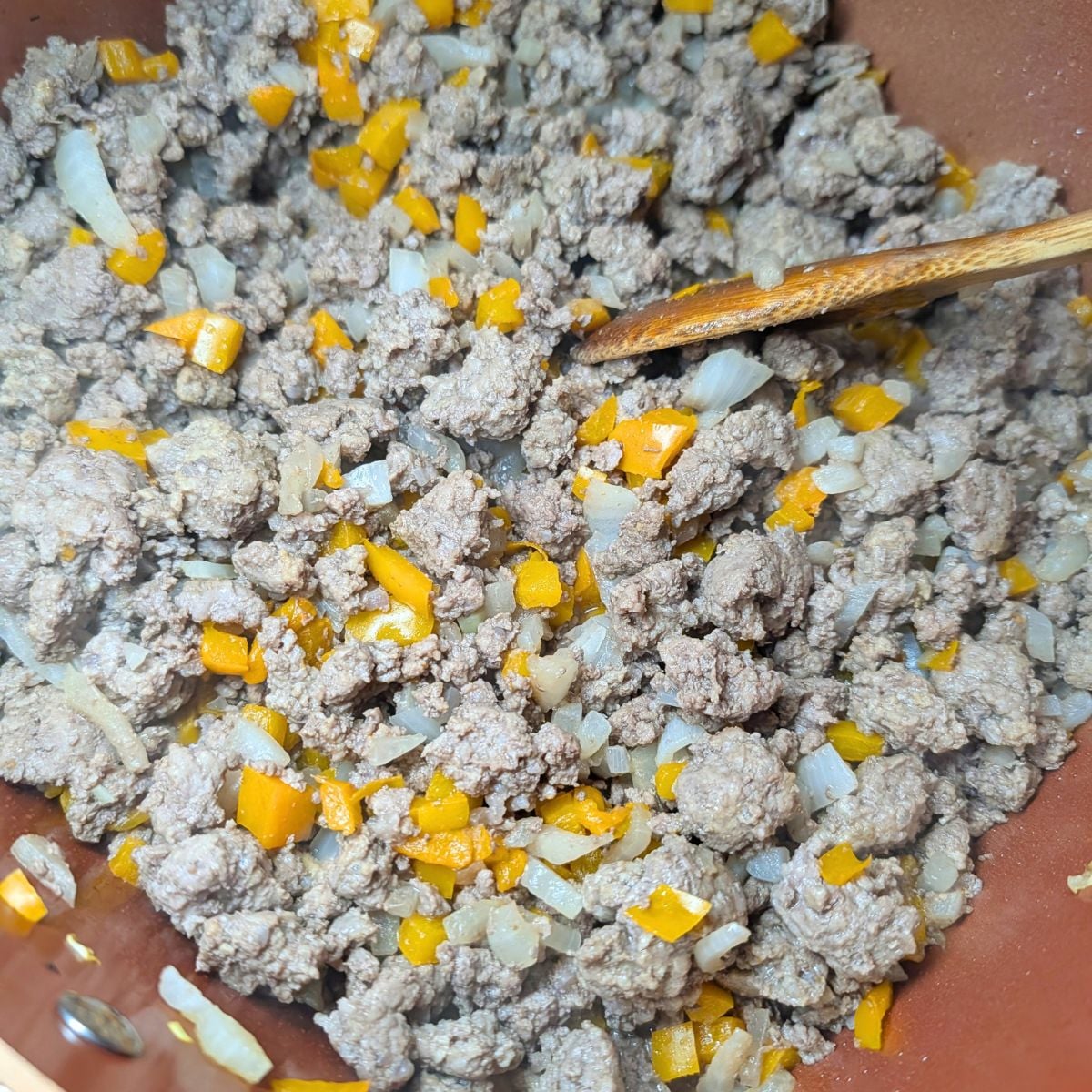 Browning ground beef and vegetables in a skillet.
