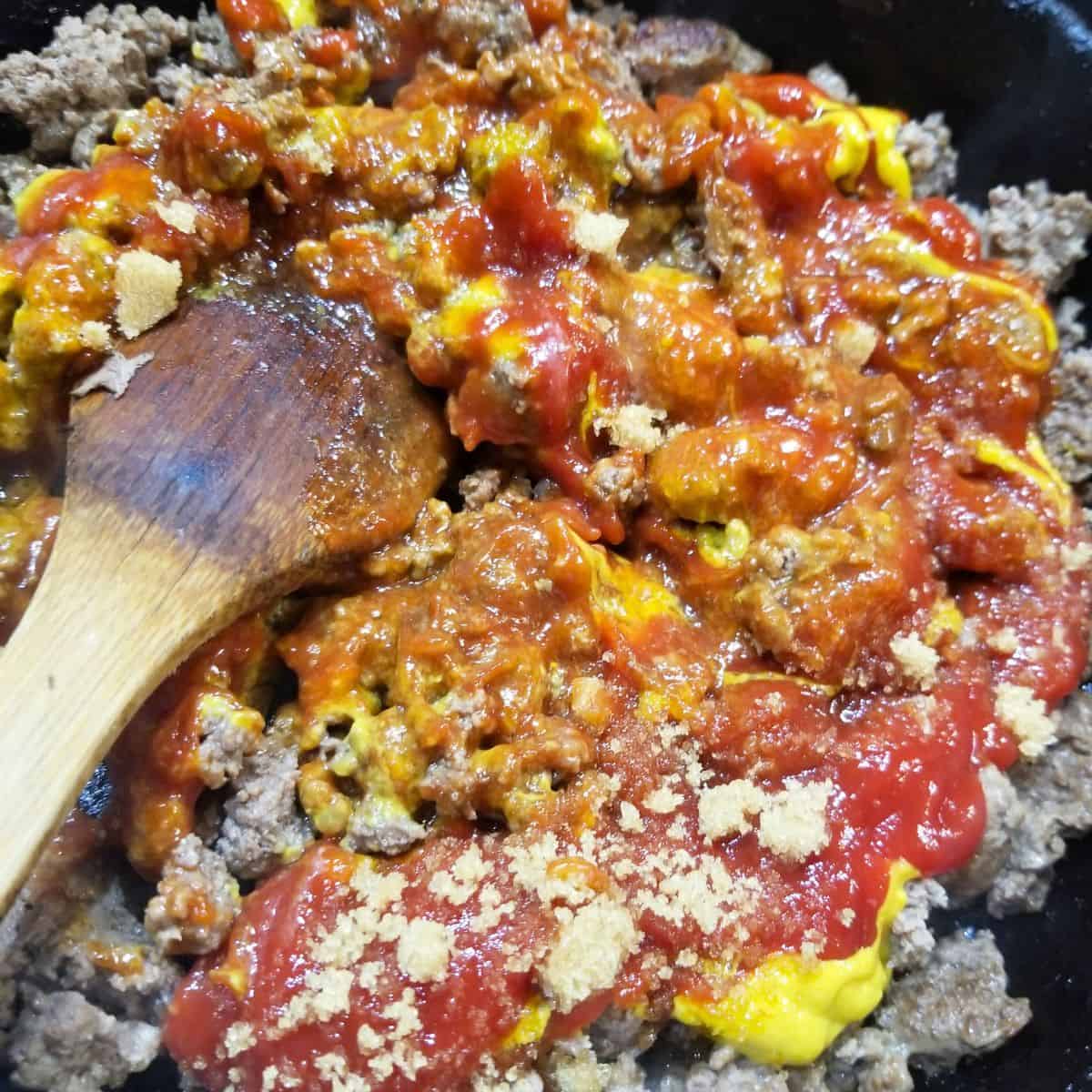 Mixing ketchup, mustard, brown sugar and Worcestershire sauce into ground beef.