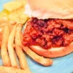 Easy sloppy joes on a bun with fries and pickles on the side.