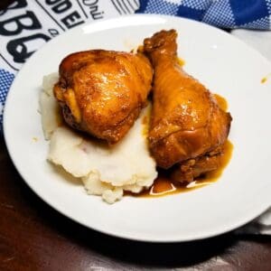 BBQ chicken over mashed potatoes in a white serving bowl.