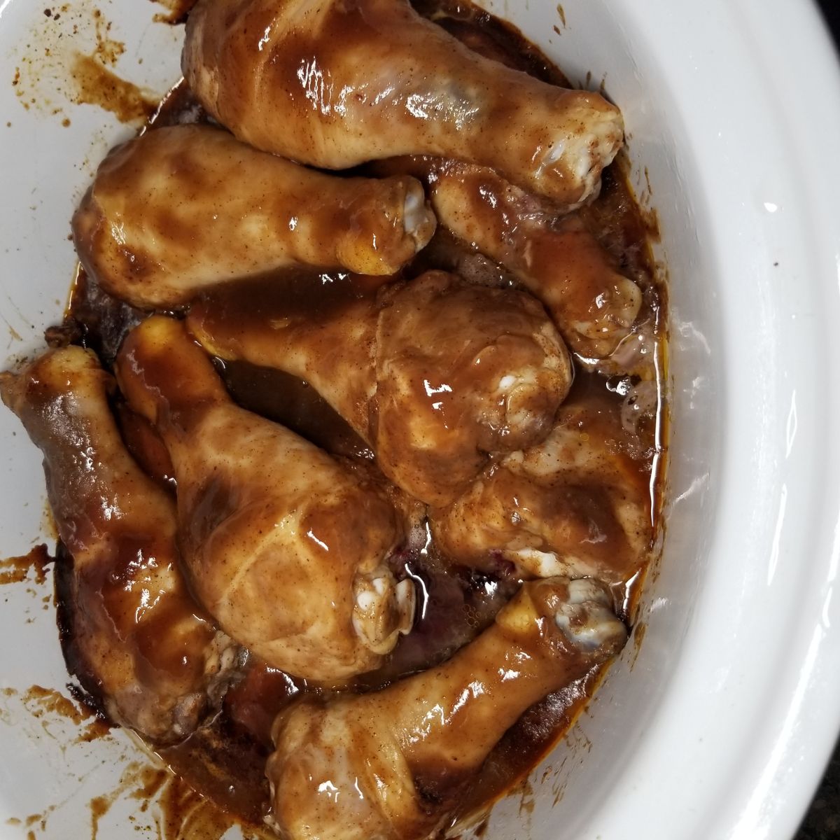 Chicken legs in a crock pot with bbq sauce.