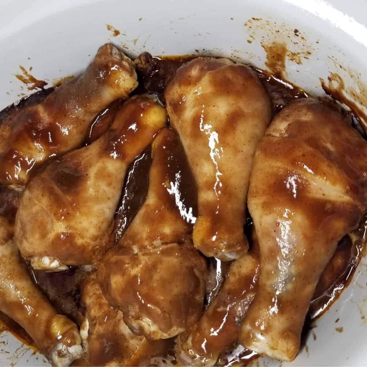 Chicken legs in a crock pot with bbq sauce.