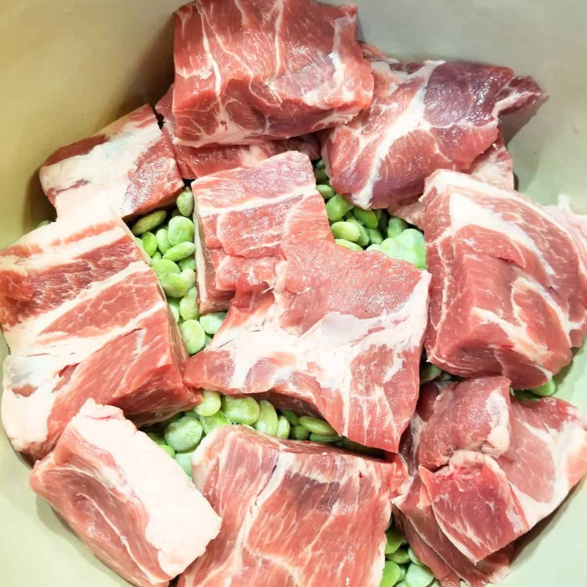 Frozen baby lima beans and neckbones in a pot.