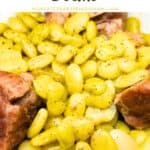 Close-up of slow-simmered Southern lima beans with meat in a white bowl.