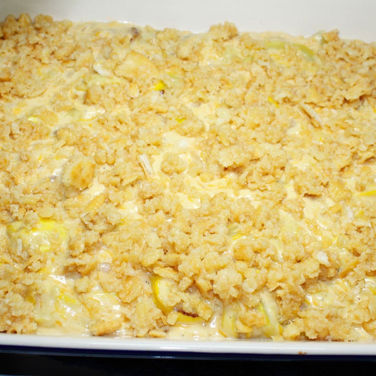 A crumb topping added to the recipe in a white baking dish.