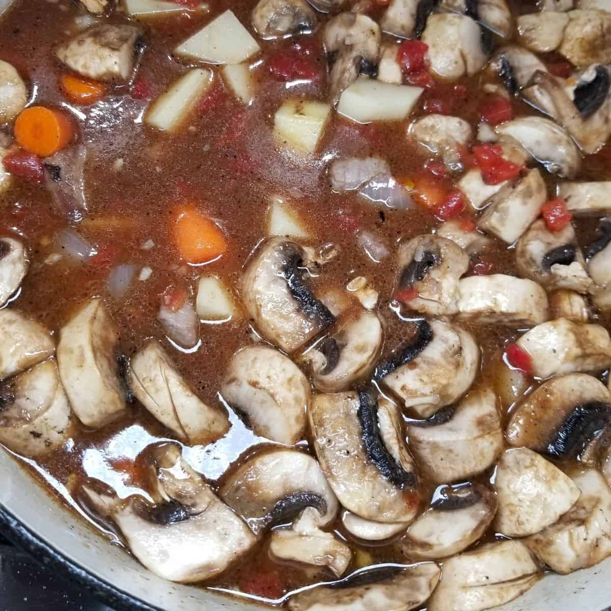 Adding hearty vegetables to the soup pot for the dutch oven beef stew.