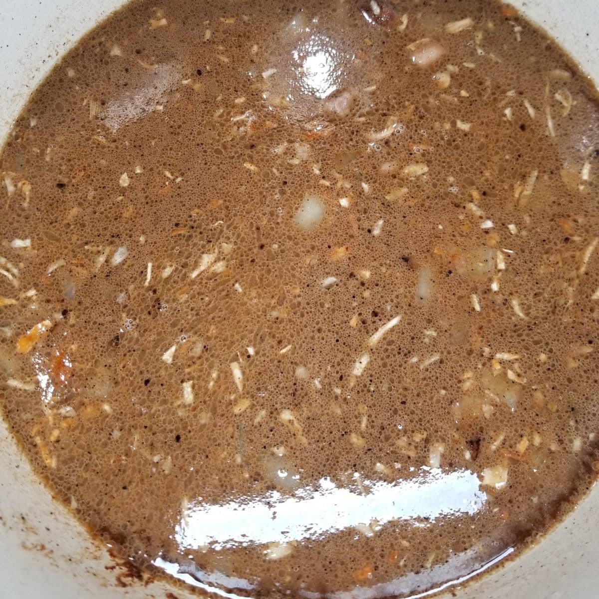 Adding liquid to the soup pot for the soup base.