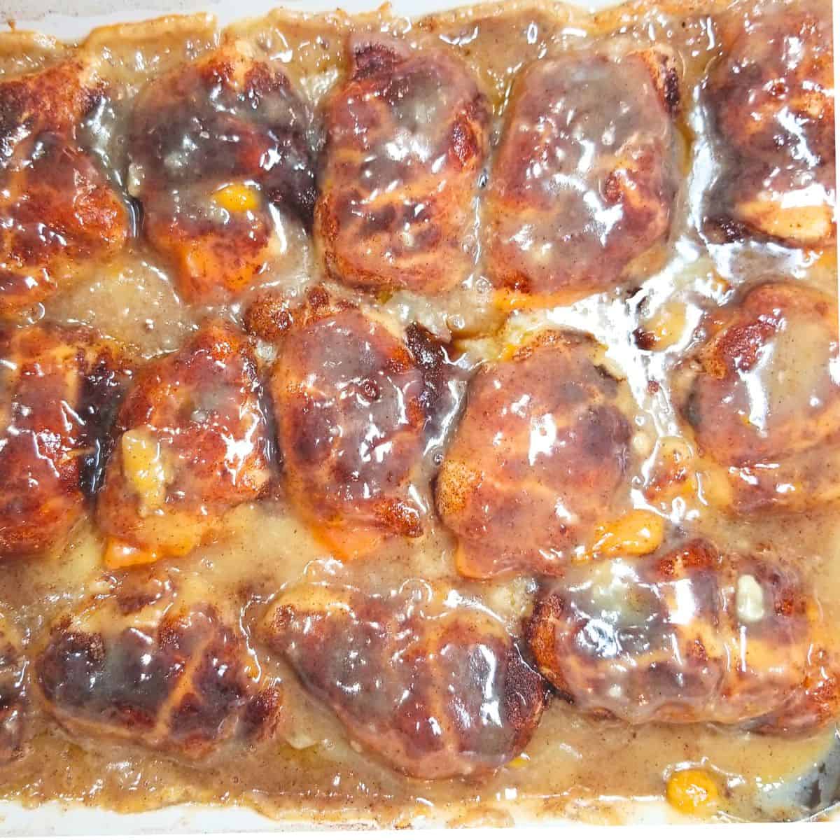 Sweet potato dumplings baked in a cinnamon sauce in a 9x13 baking dish.