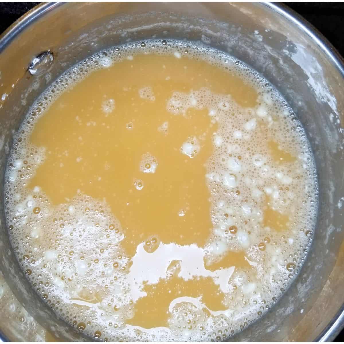 Evaporated milk, sugar, salt, and cornstarch cooking in a saucepan for sauce.