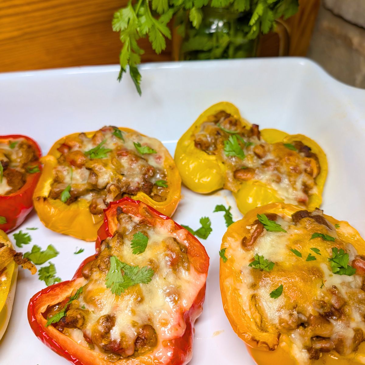 Cooked stuffed bell peppers in a white baking dish.