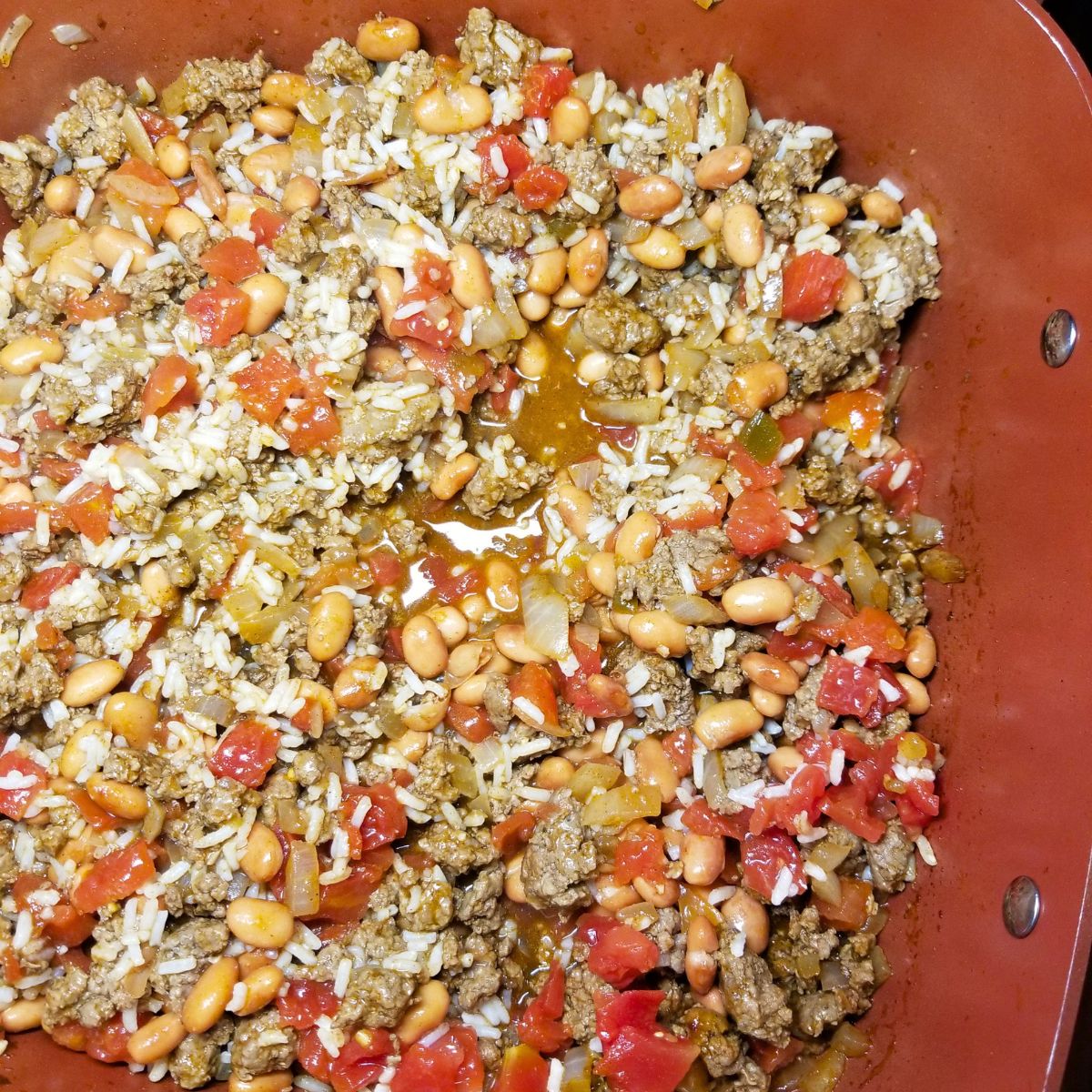 Cooked taco filling for the peppers in a skillet.
