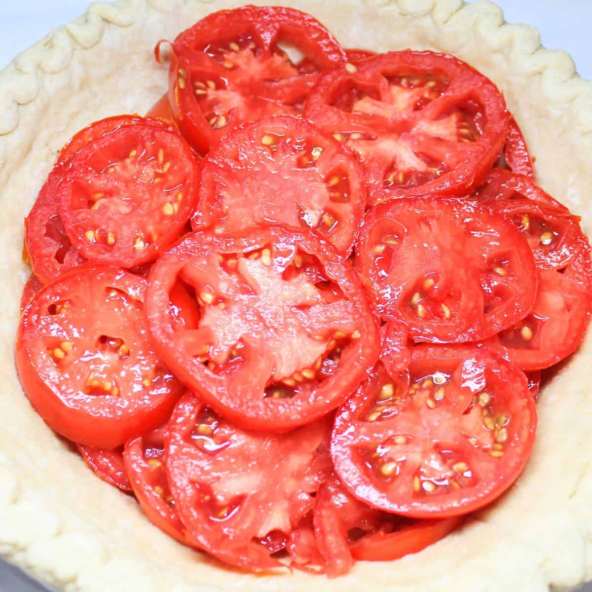 Sliced tomatoes in a pie crust.