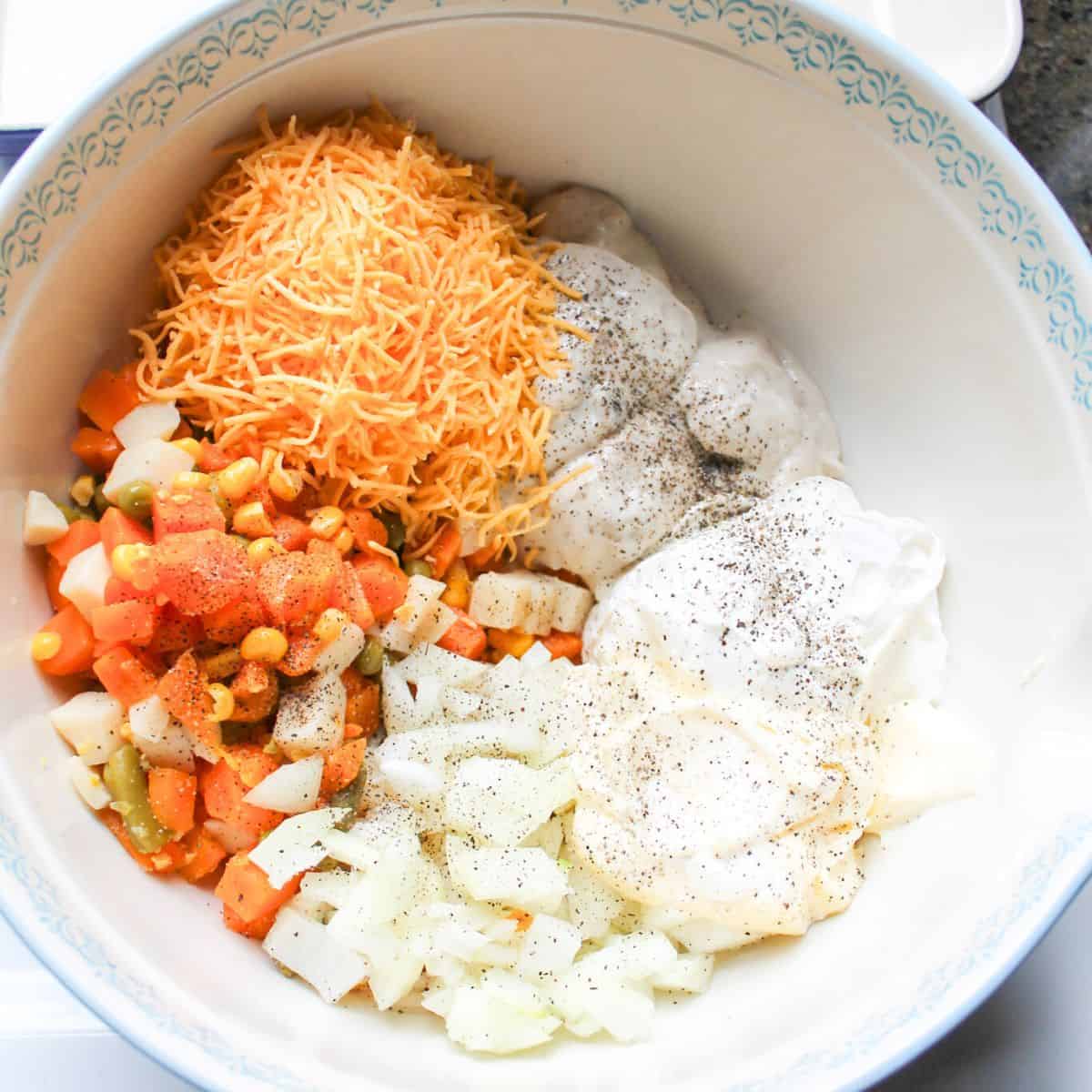 Ingredients for making veg all casserole in a blue and white bowl.