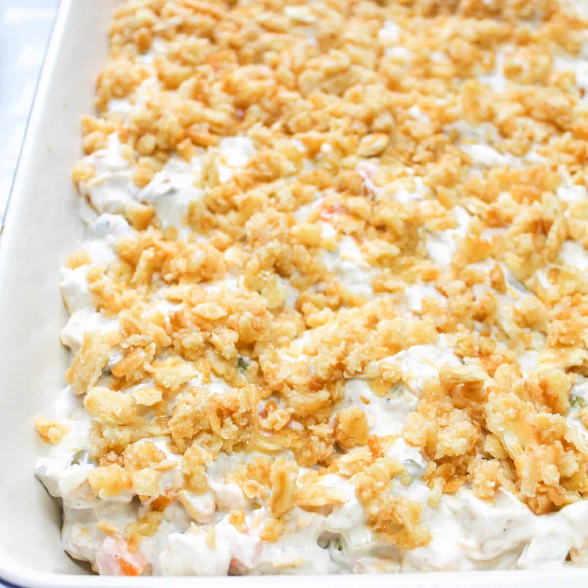 The mixed ingredients in a casserole dish with buttery cracker crumbs over the top.