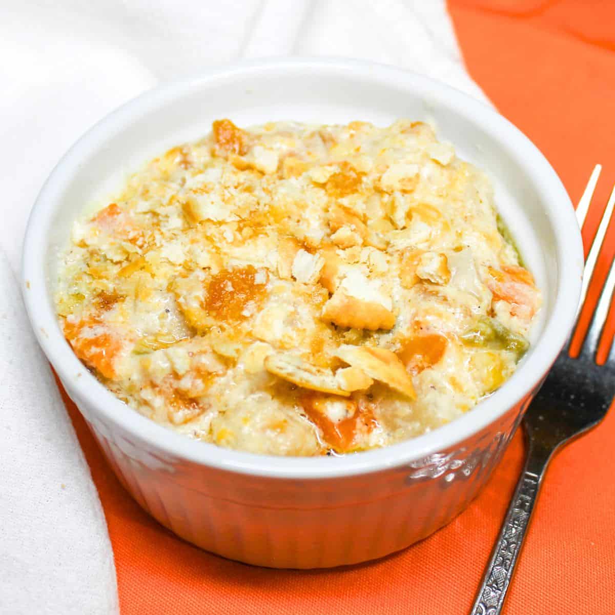 Veg All casserole in a white bowl with a fork on the side.