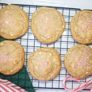 Peppermint cookies on a wire rack with stripped dishtowels and peppermint candy.