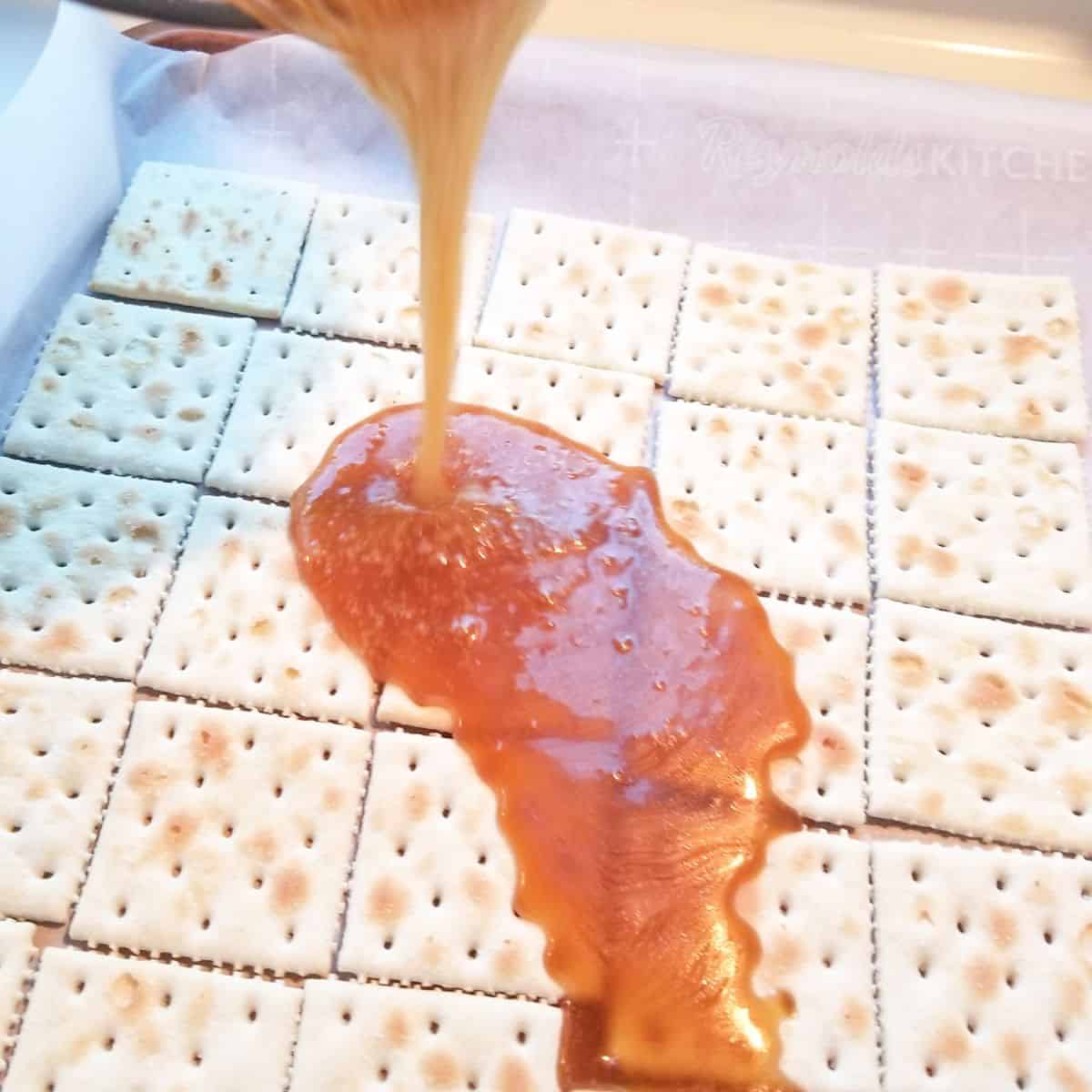 Pouring toffee over saltine crackers.