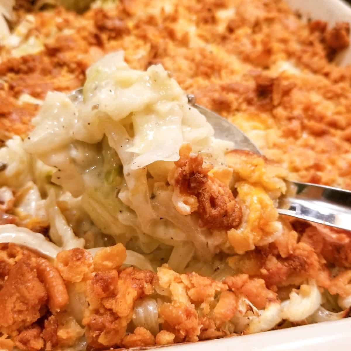 Finished recipe for cabbage casserole with a metal spoon.