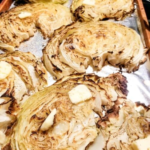 Roasted cabbage steaks on a baking sheet.