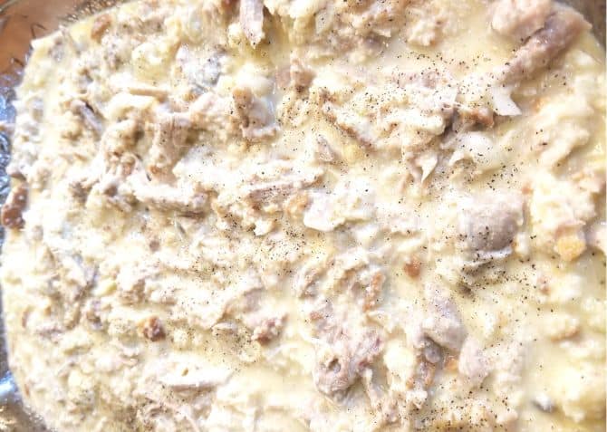 Unbaked Chicken and Dressing in a baking dish.