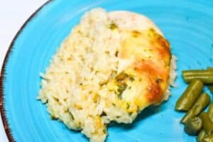Chicken Rice-A-Roni casserole on a blue plate with green beans.
