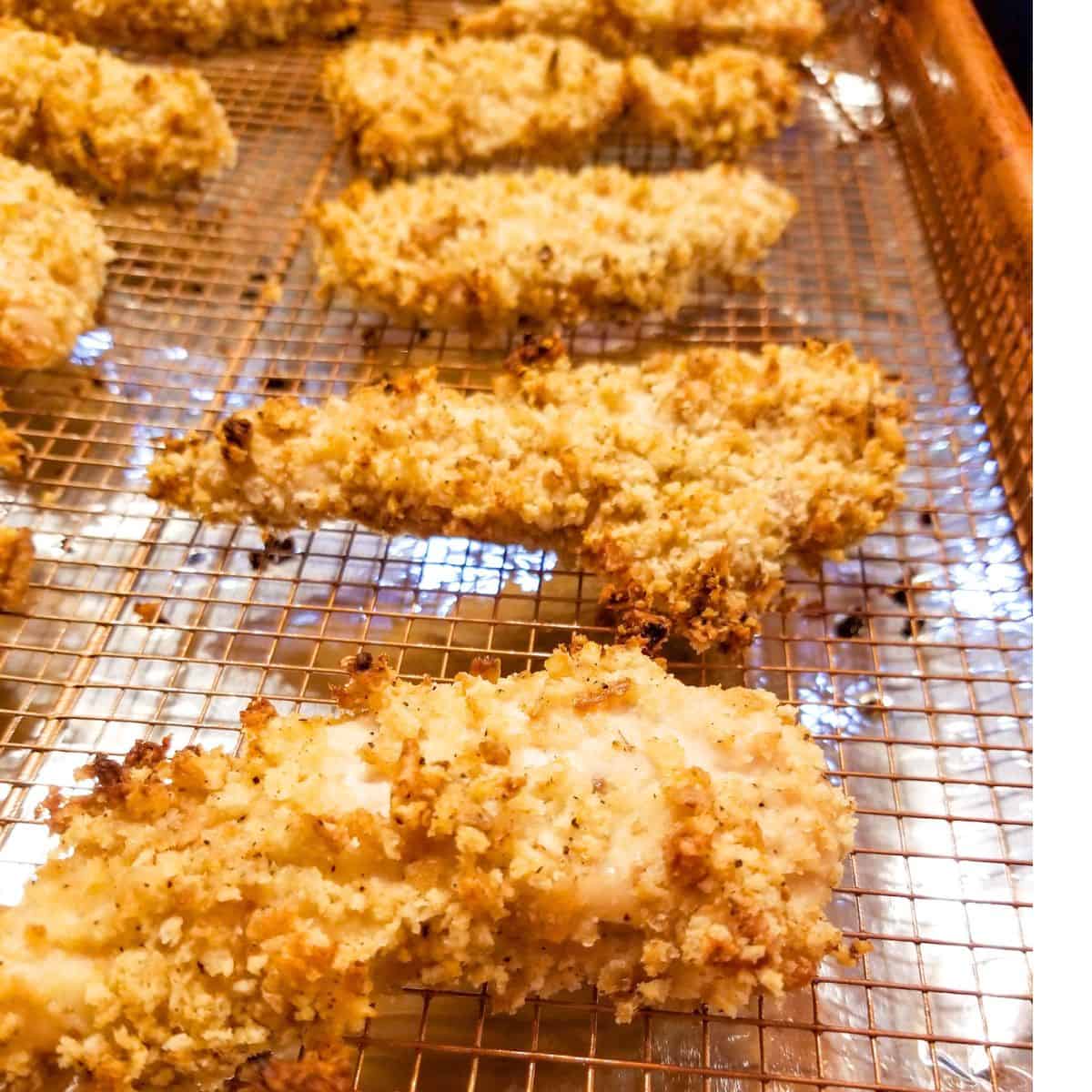 Oven baked chicken tenders on a baking rack.