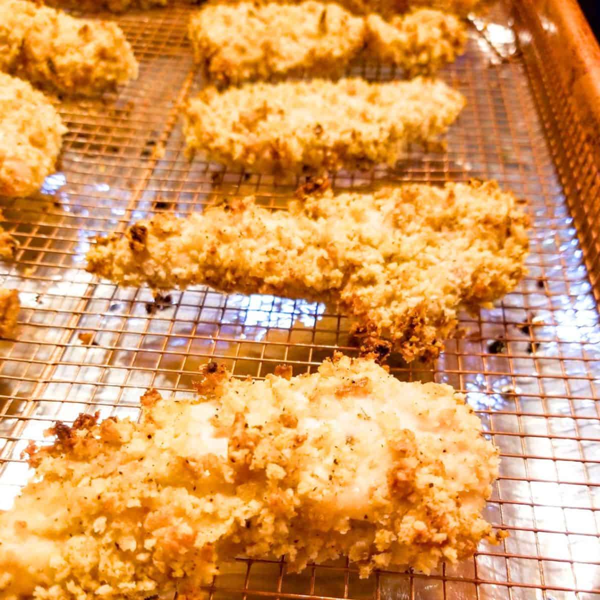 Cooked chicken tenders on a wire rack.