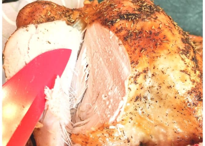 Cooked turkey on a plate with a red knife.