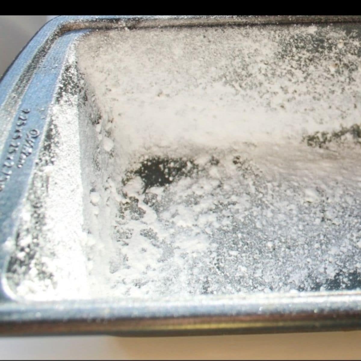 A greased and floured loaf pan for making bread.