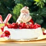 Cranberry Jalapeno Dip on a block of cream cheese with a Santa decoration, peppermint, and a Christmas tree in the background.