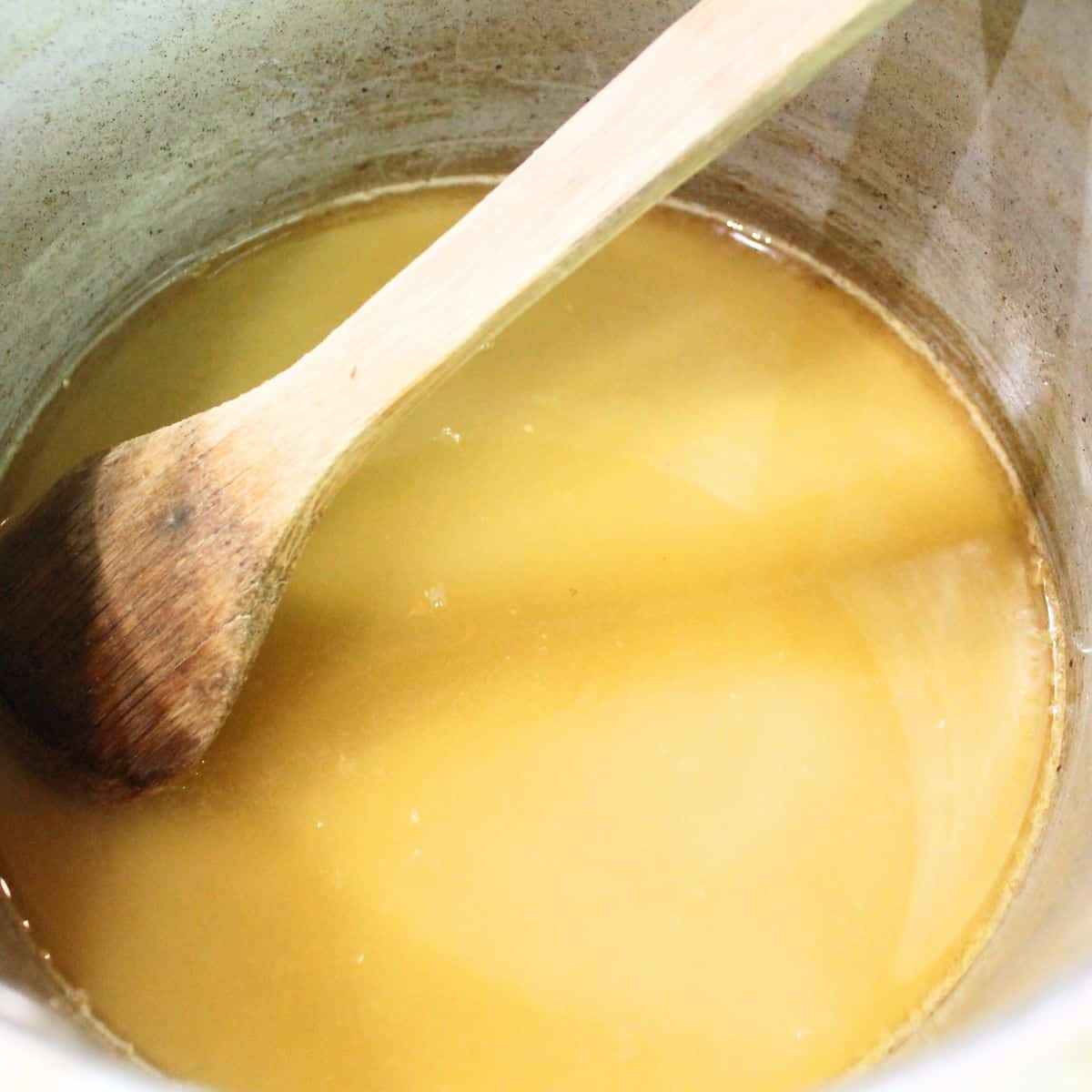 Boiling ingredients in a pot with a spoon.
