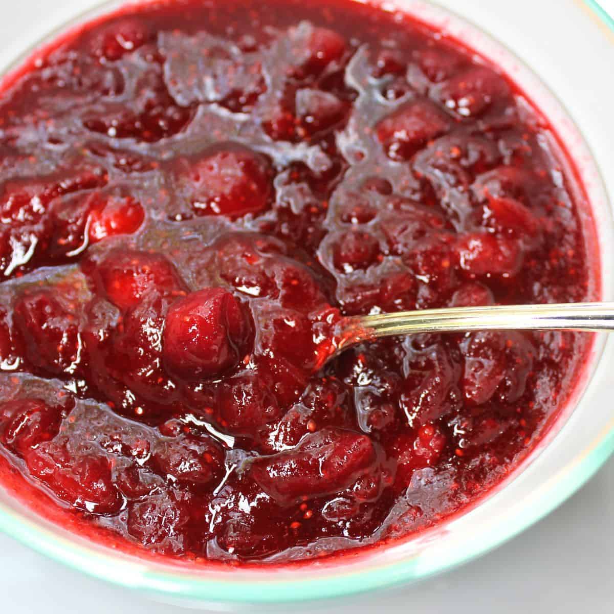 Fresh cranberry sauce in a bowl with a spoon.