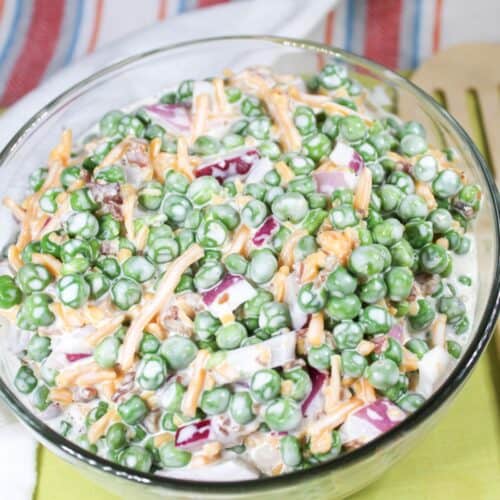 Pea salad in a bowl sitting on dish towels.