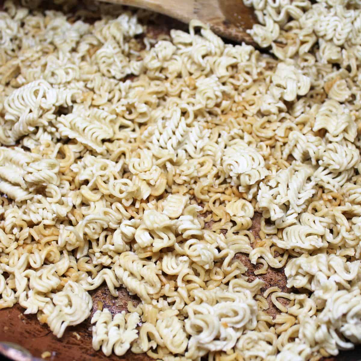 Toasted ramen noodles in a pan.