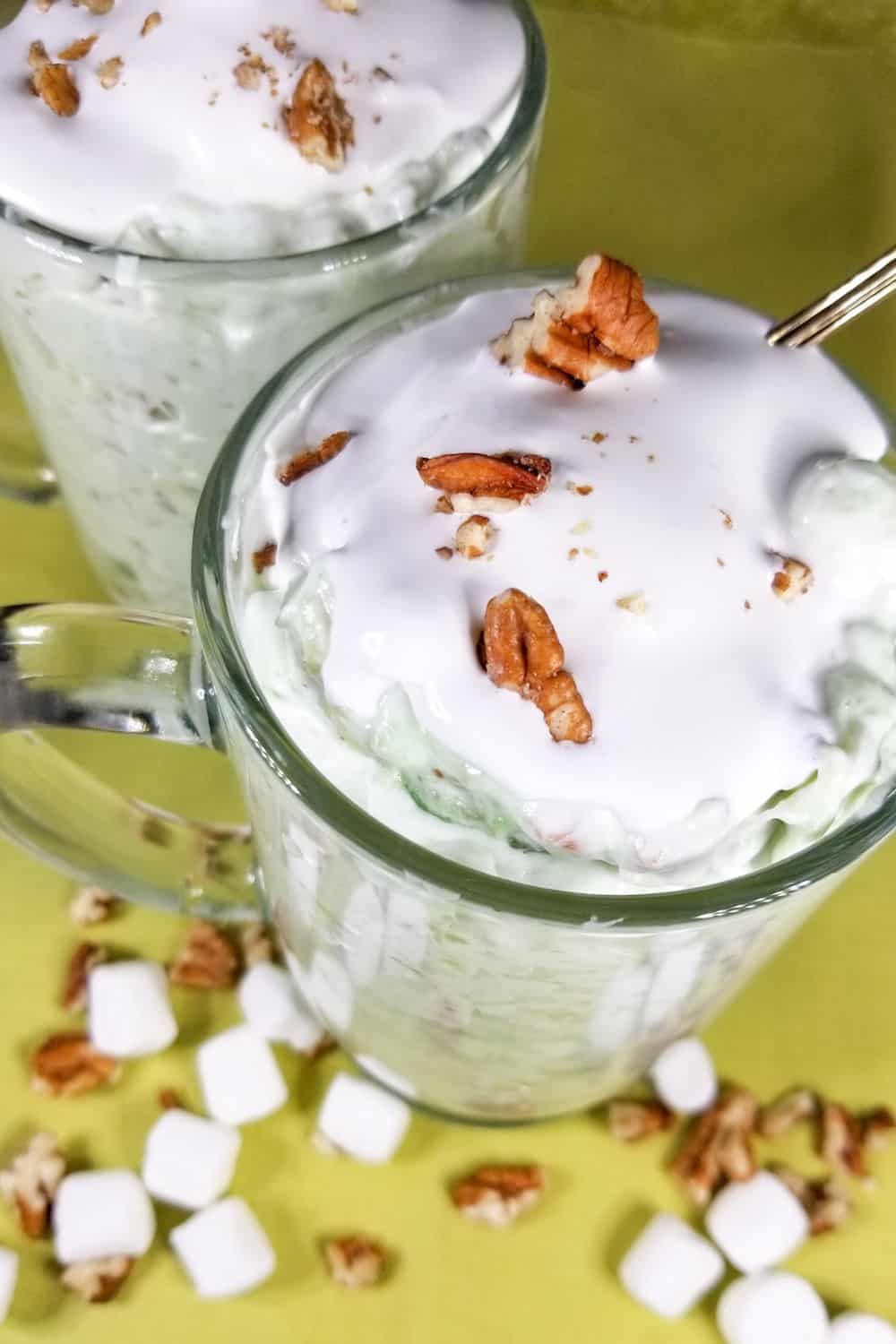 Watergate Salad on a green table with nuts and marshmallows.